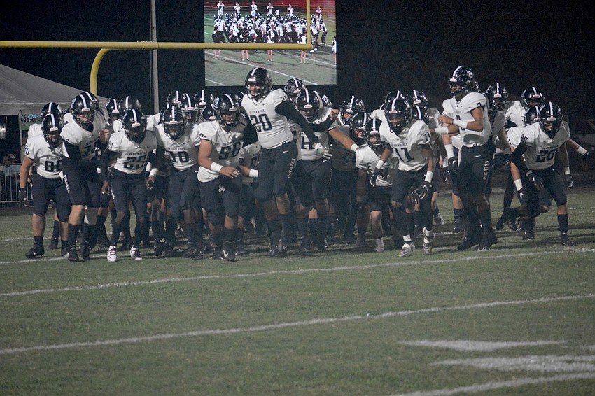 The Pirates take the field through a cloud of smoke.