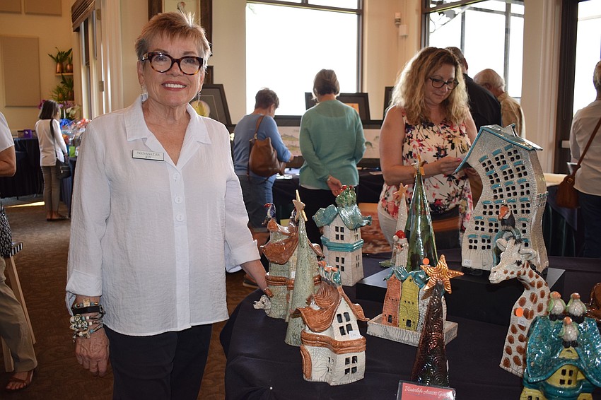 Sue Kerr's unique raku fired clay sculptures catch the eye of several viewers at the Waterlefe Art Show. Kerr started with raku firing clay after taking a class at Art Center Manatee eight years ago.