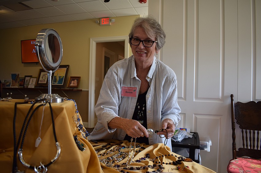 Bonnie Schar changes her display of jewelry during the Waterlefe Art Show. Schar has been making jewelry for 30 years and painting for more than 50 years.
