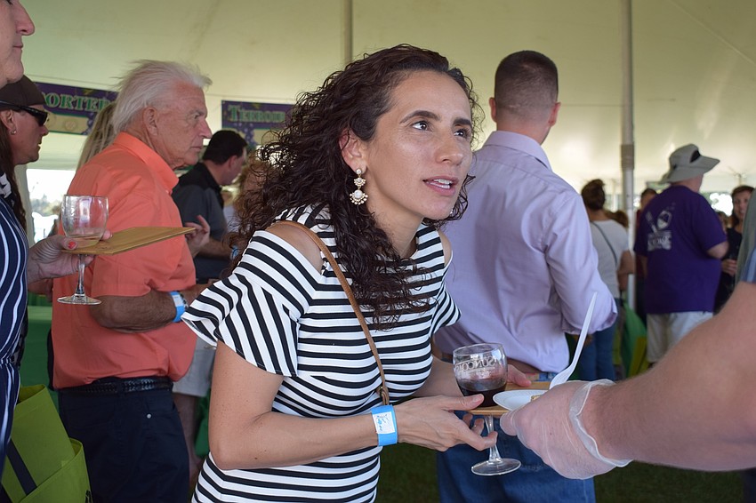 Sarasota resident Mary Garcia gets a sample of food during the Suncoast Food and Wine Fest. Garcia and her husband, Miguel, said the fest is a social event where they run into people they know while also meeting new people.
