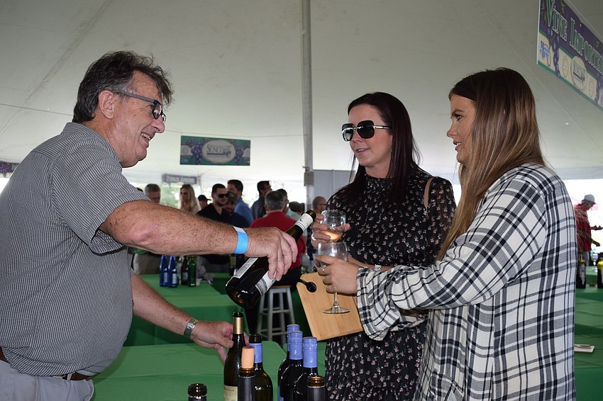 Fran Schoepfer, a sales manager for Vine Importers, gives a sample of Midnight Estate wine to Sarasota residents Lindsey Meshberger and Shannon Lynch.