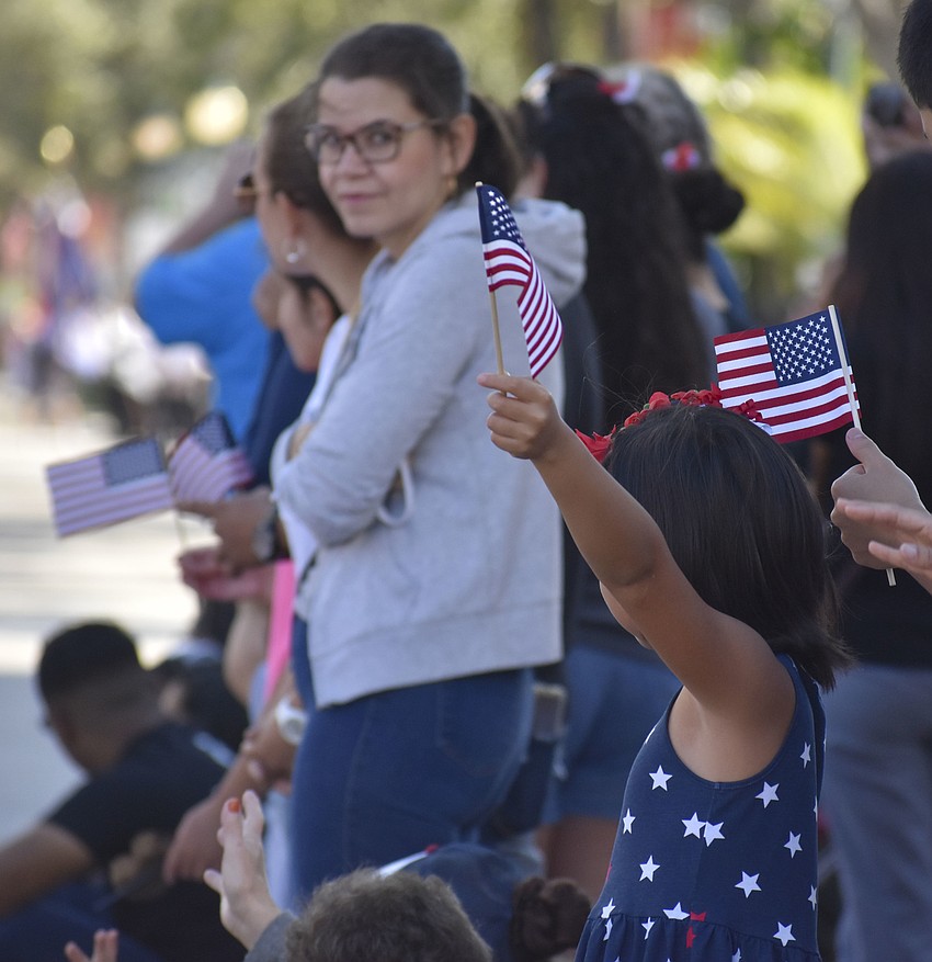 Julia Stochl, 8, waves her flag as the parade goes by.