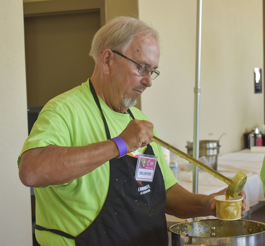 Jim Shafer ladles lentil soup from the Curry Station into a cup for a guest.