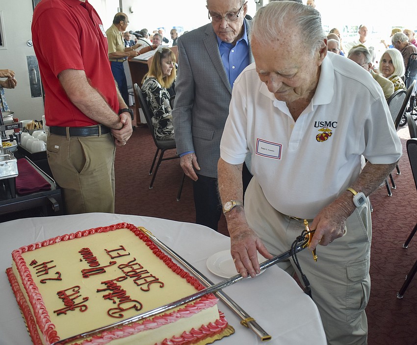 Ralph Franklin, 99, cuts the birthday cake with a sword.