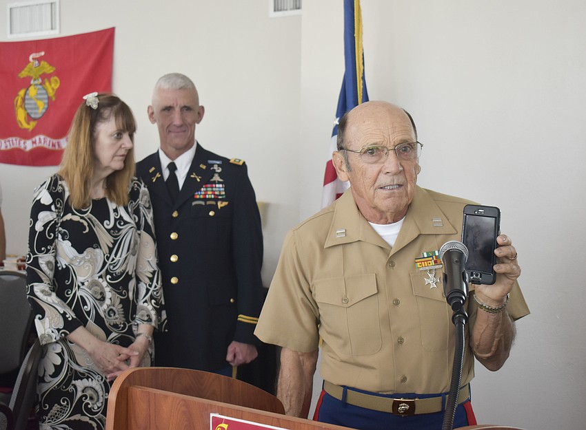 Thomas Smith holds his phone to the microphone to play 