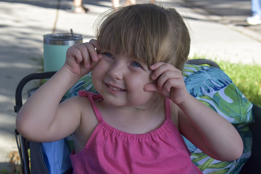 Ava Kane, 3, smiles as she's pulled around Porchfest in her wagon.