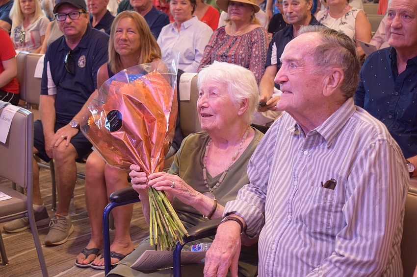 Rose Bauer holds flowers that were given to her as her husband of 73 years, Reinhard Edward Bauer, was honored during a Veterans Day ceremony at Del Webb.