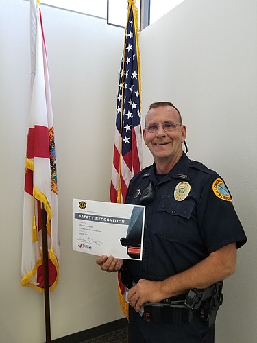 Officer Shawn Nagell stands with the safety recognition award he received for his work during the 2019 Click It or Ticket National Campaign. (Courtesy of Town of Longboat Key Police Department)