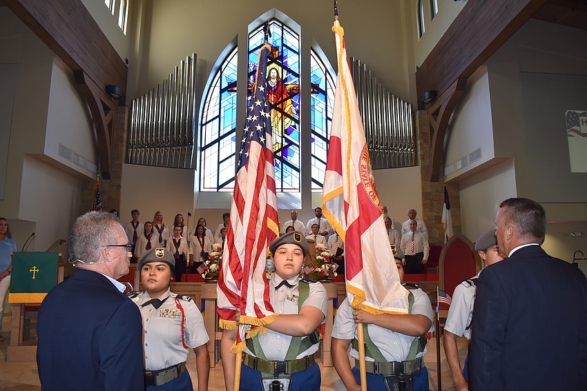 The Junior ROTC members carry the colors out of the church.
