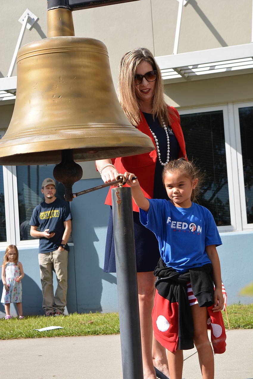 Assistant Principal Michele Danowski helps Emma Valentin ring the bell in the Let Freedom Ring Courtyard.