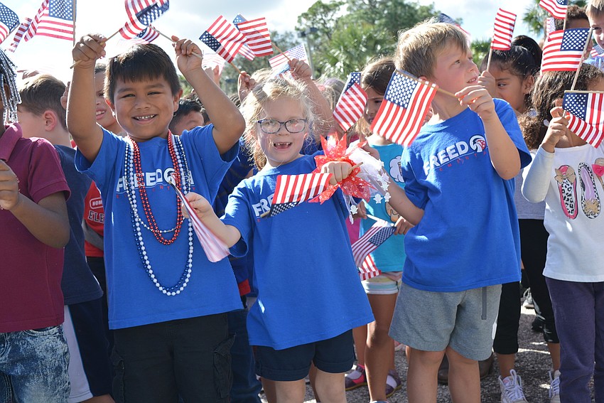 Kindergarten students Victor Montemayor, Katelyn Pearce and Keelan Mitchell happily waved American flags during the last song of the courtyard ceremony.