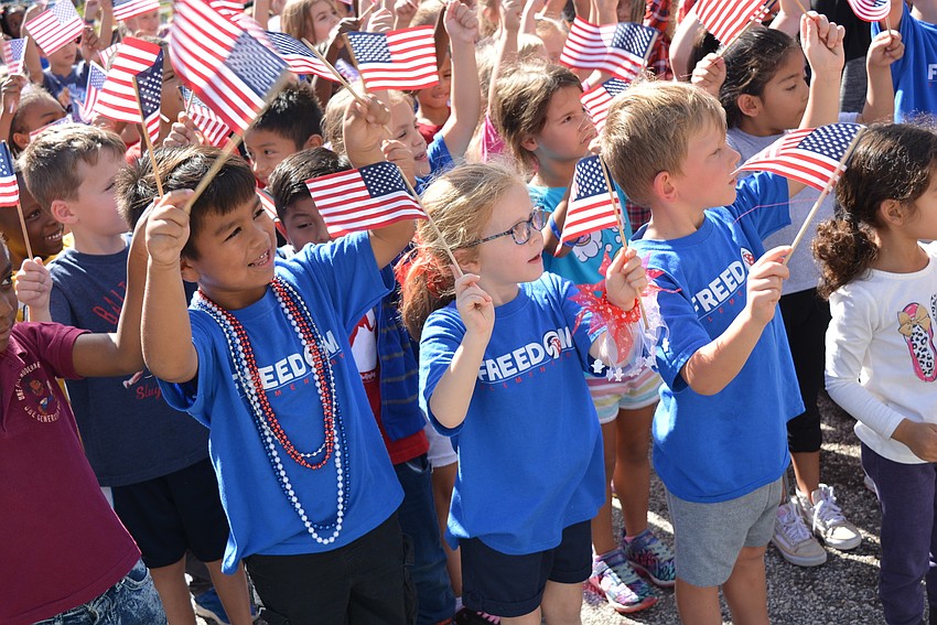 Kindergarten students Victor Montemayor, Katelyn Pearce and Keelan Mitchell happily waved American flags during the last song of the courtyard ceremony.