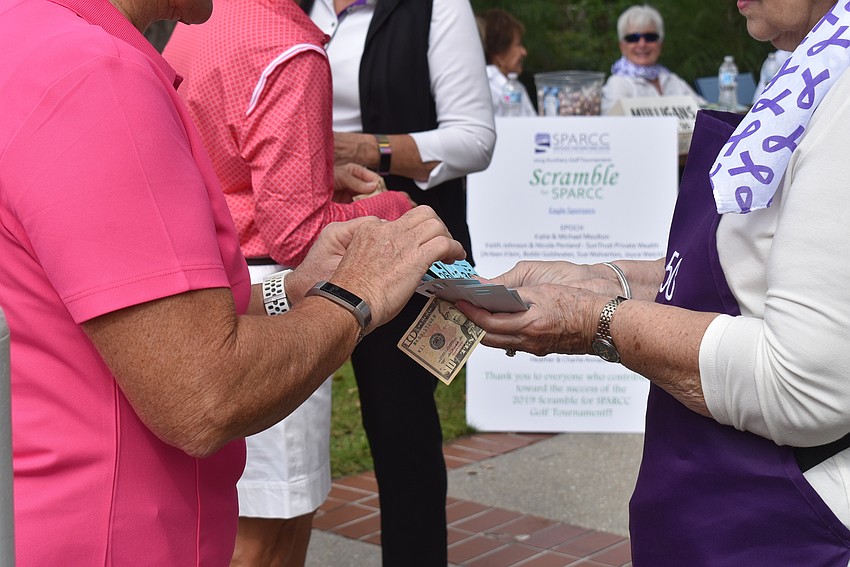 Becky Smothers chooses a raffle ticket from Annette Seibert.