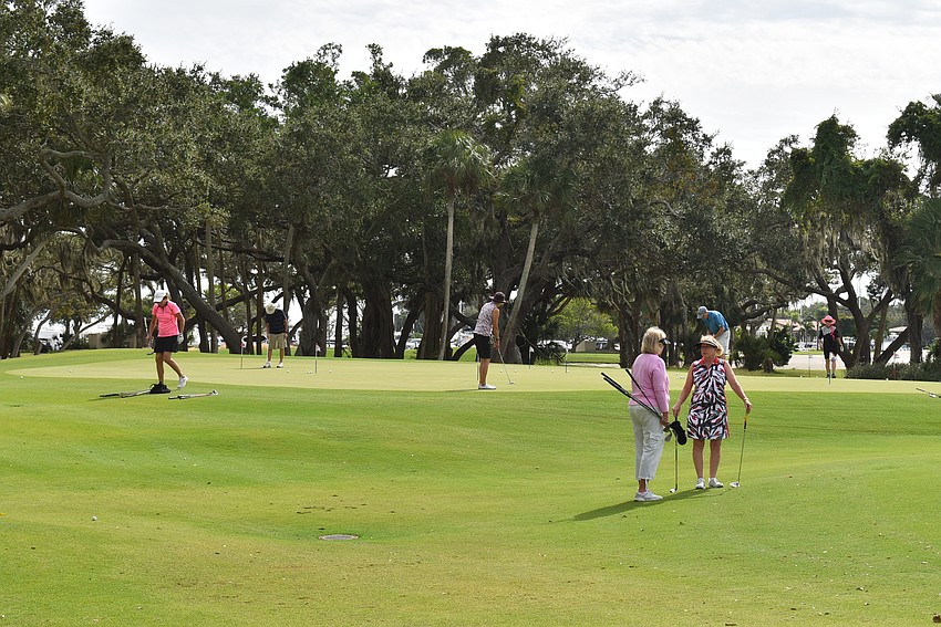 Golfers hit the putting green before hitting the links for real.