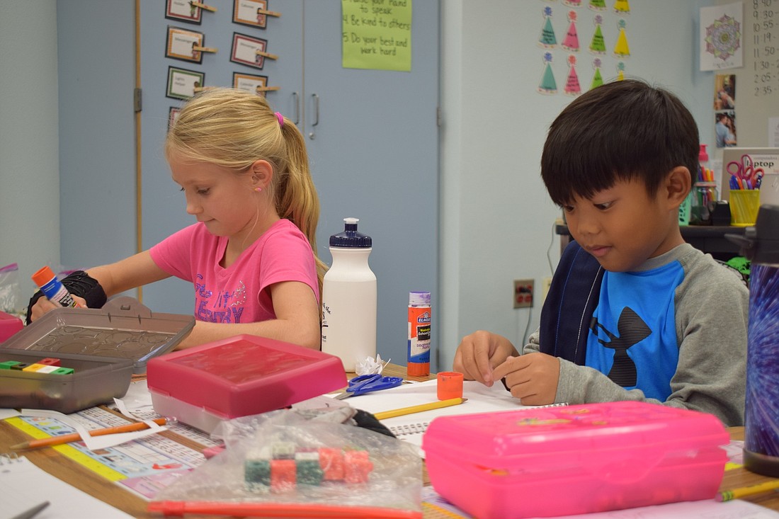 Paisley Gabbard and Wesley Hoben, first graders at Gene Witt Elementary School, work on an assignment during class.