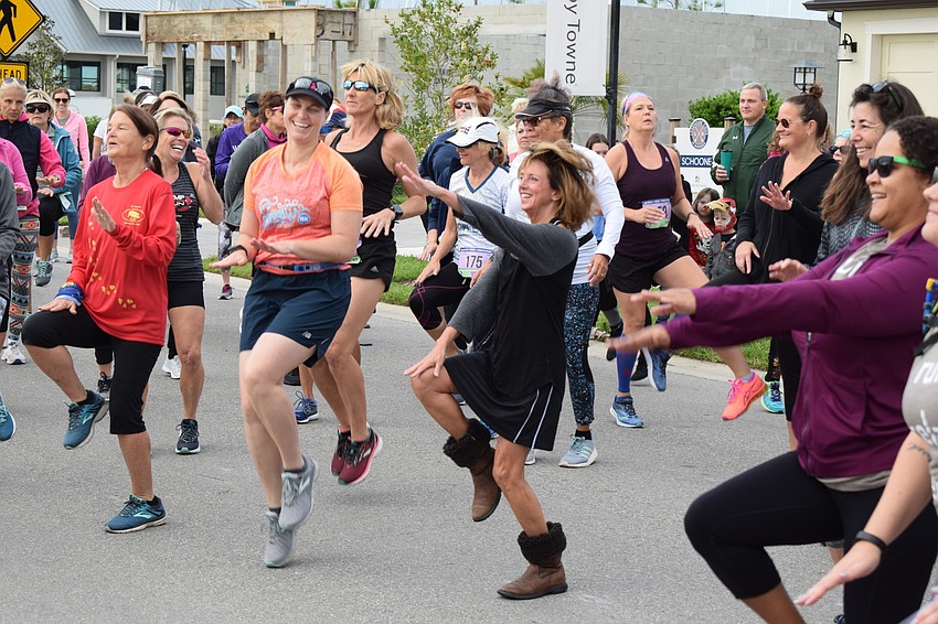Brain Health Initiative Executive Director Stephanie Peabody (center) helps warm up the runners before the 5K. She obviously was not running in the 5K with those boots.