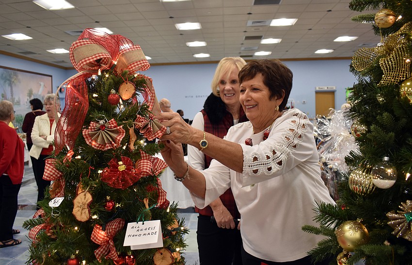 Elaine Cichon fixes ribbon on one of the trees for sale.