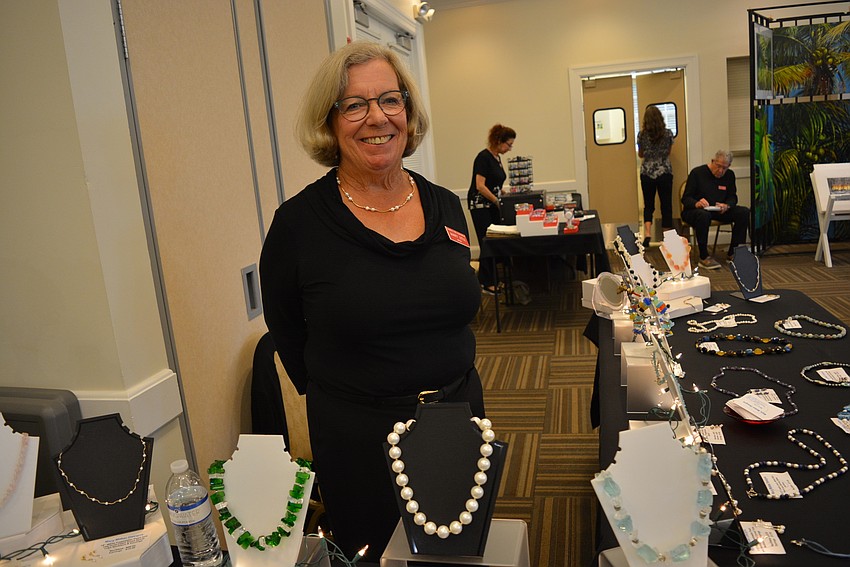 Artist Mary Little showcases her beaded necklaces as guests enter the show.