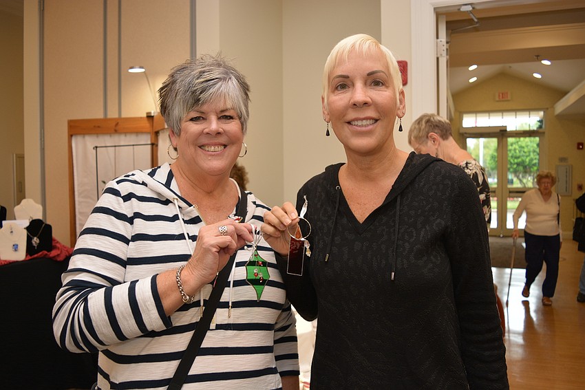 Waterlefe Golf & River Club residents Cheryl Hughes and Barb Lee purchase stained glass ornaments from artist Carol Krah.