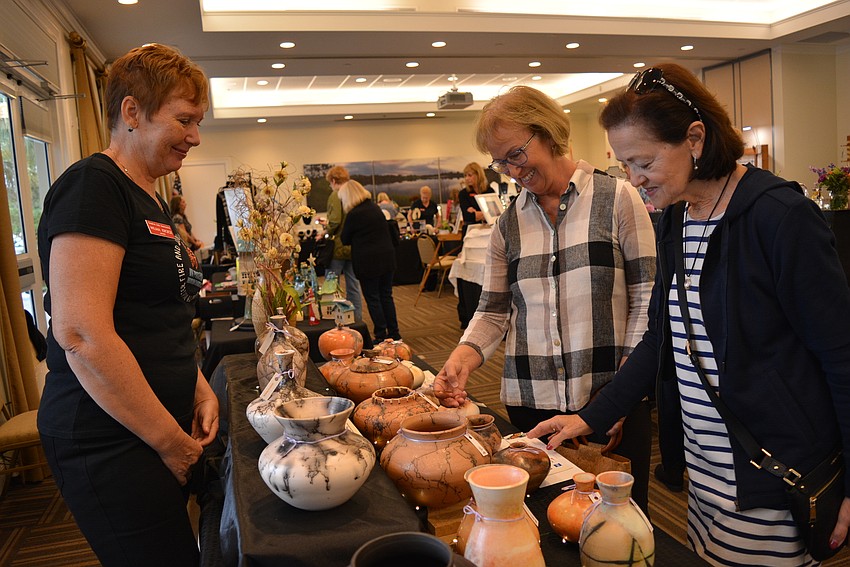Artist Wilma Kroese answers questions about her pottery  from Donna Hartung and Anita Johnston, both of Waterlefe Golf and River Club.