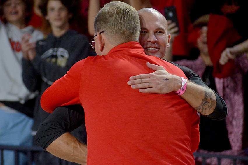 Cougars coach Chad Sutton hugs Cardinal Mooney principal Ben Hopper after the victory.