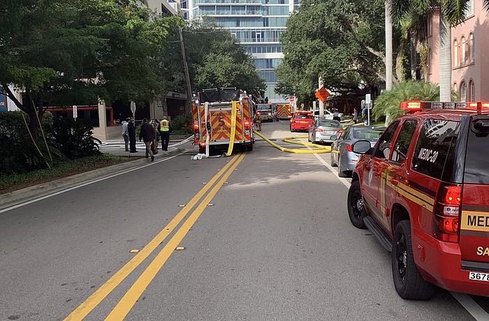 Office workers watched on the street as the Sarasota County Fire Department responded to the vehicle fire Monday morning. Photo courtesy Sarasota Police Department.