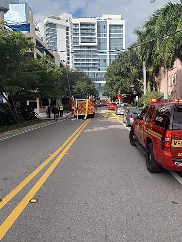 Office workers watched on the street as the Sarasota County Fire Department responded to the vehicle fire Monday morning. Photo courtesy Sarasota Police Department.