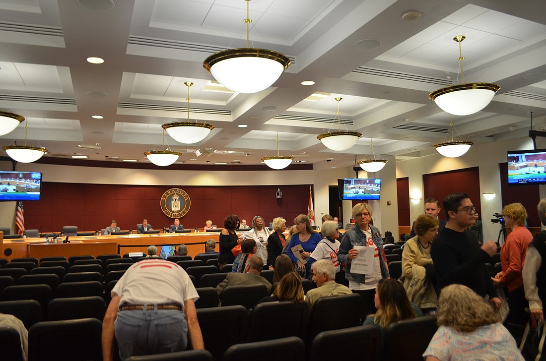 Members of the public filed out of the commission chambers as the County Commission discussed the adoption of a new district map.