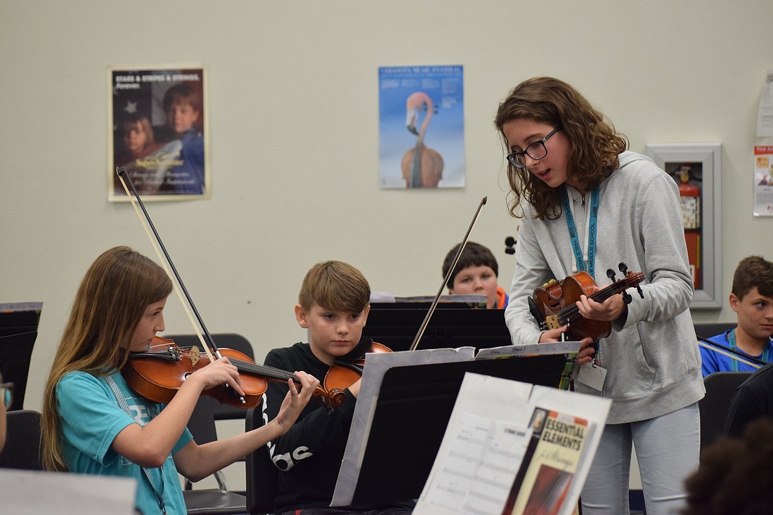 Tiffany Rock, a seventh grader, works through a few measures with sixth graders Kiera Woefel and Coltin Cramer. "Itâ€™s pretty cool to imagine I was them last year," Rock said.