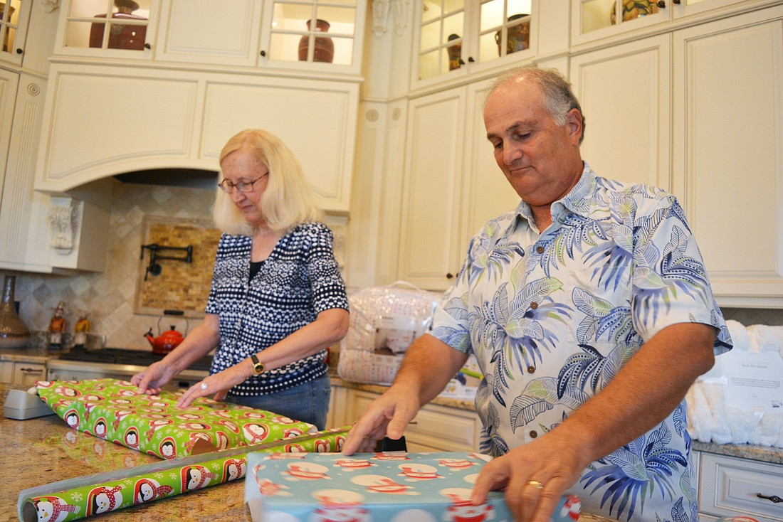 The Lake Club residents Marybeth and Jay Traverso have temporarily converted their kitchen island into "Santa&#39;s workshop" as they gather gifts for a family in need. They have had fun shopping for toys and other needs.