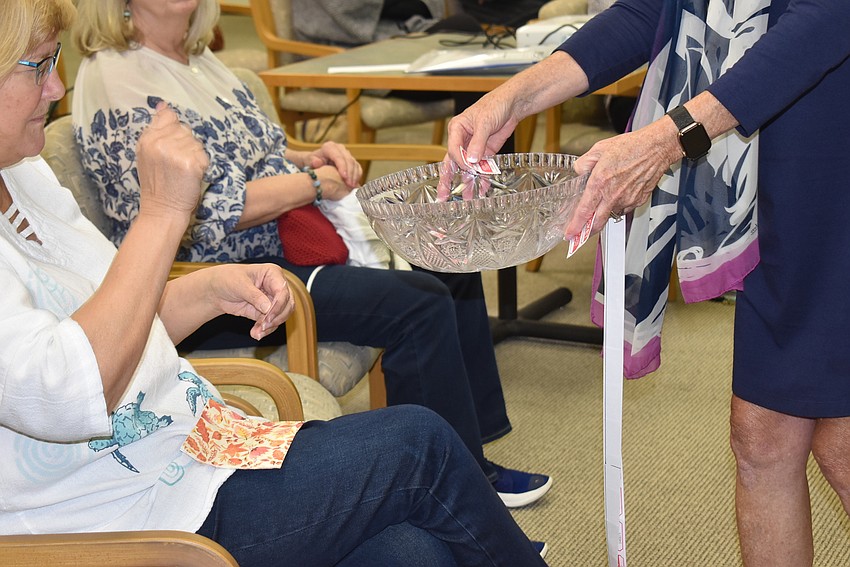 Deborah Purdum drops her ticket in the bowl to win a flower arrangement.