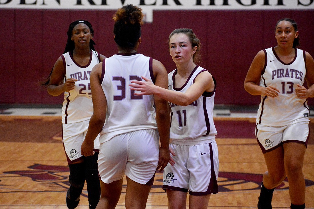 Julia Rodriguez (32) gets a hug from Ellie DiGiacomo after getting fouled, as Aaliyah Capers (25) and Bella Patterson (13) jog up the court.