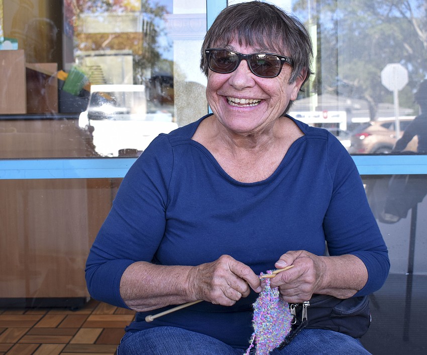 Domenique Maitre knits new items to sell during the festival.