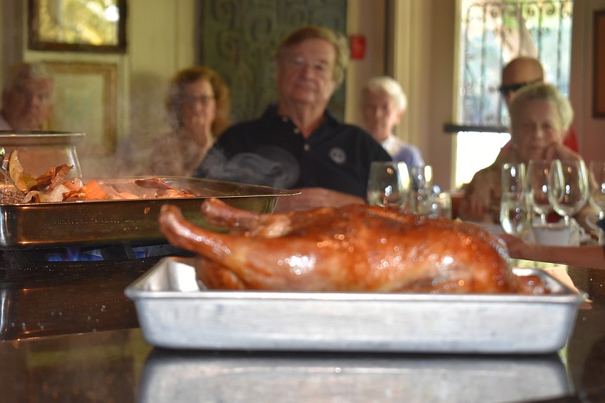 A perfectly crisp duck waits to be cut and served.