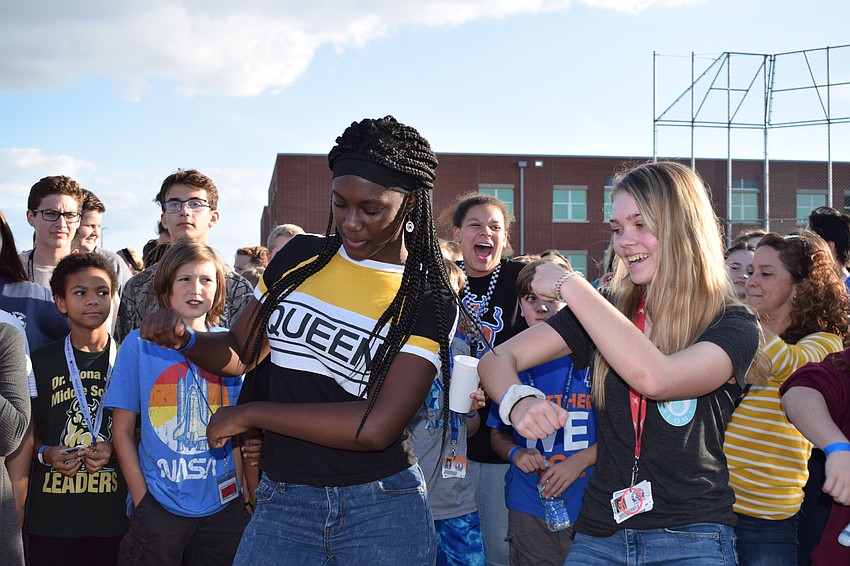 Laila Ward and Caitlyn Webb, both eighth-graders, lead a group of students during a school-wide dance party at the end of the walk-a-thon.