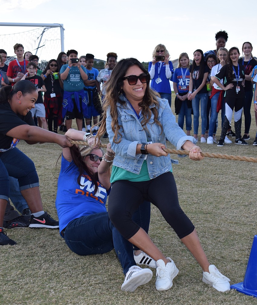Wende Wicks, a reading teacher, falls as Jillian Cucci, an intensive reading teacher, holds on during a round of tug of war. 