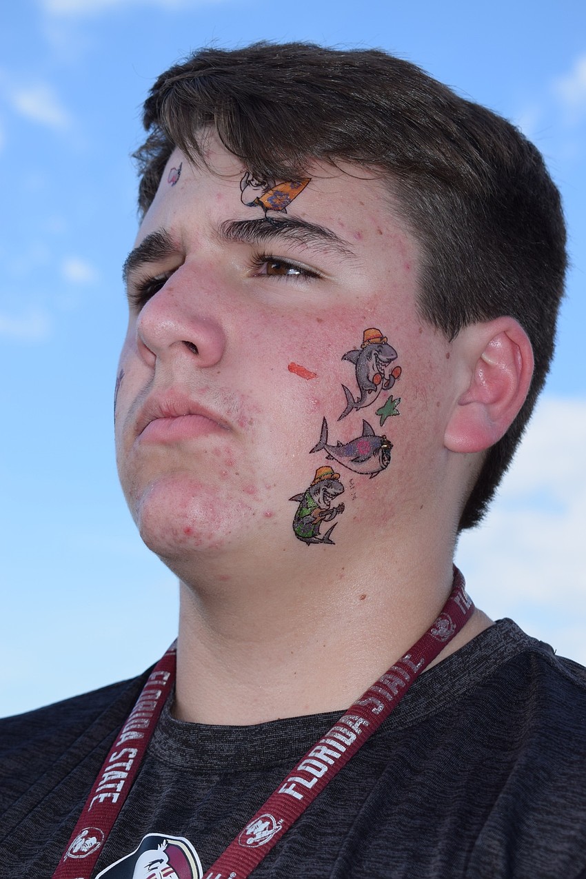 Conner Coffaro, an eighth-grader, put several temporary tattoos on his face and arms.