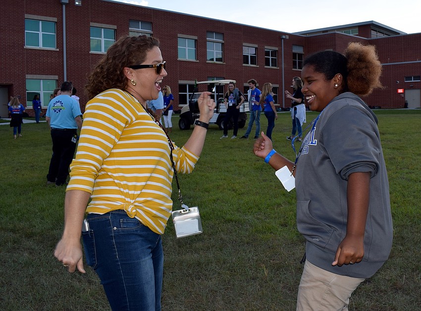 Art teacher Jeannie Mendez dances with seventh grader Tykia Robinson.