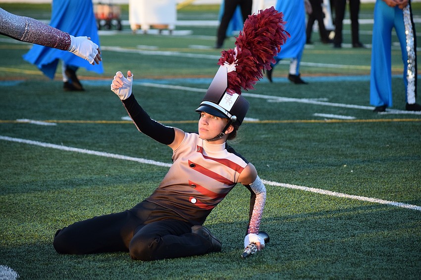 Braden River freshman Abigail Baatz receives help to rise up from the ground during the band's performance of its show 