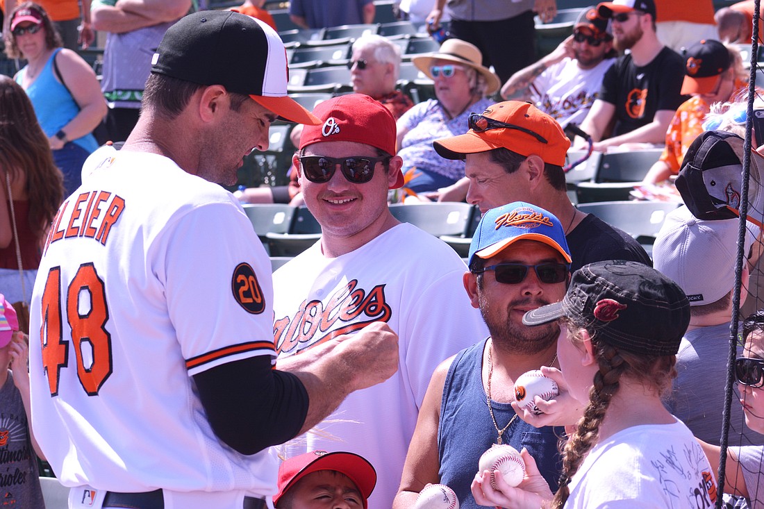 Orioles relief pitcher Richard Bleier signs autographs for fans at Ed Smith Stadium.