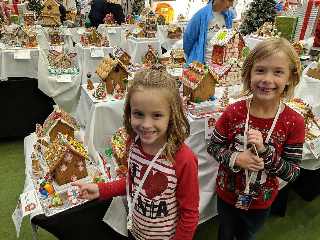 Girl Scouts Mylee Gilbert, 9, and McKinlee Gilbert, 8, show off their gingerbread houses at the annual Gingerbread Festival at the Mall at UTC in 2018. Courtesy photo.