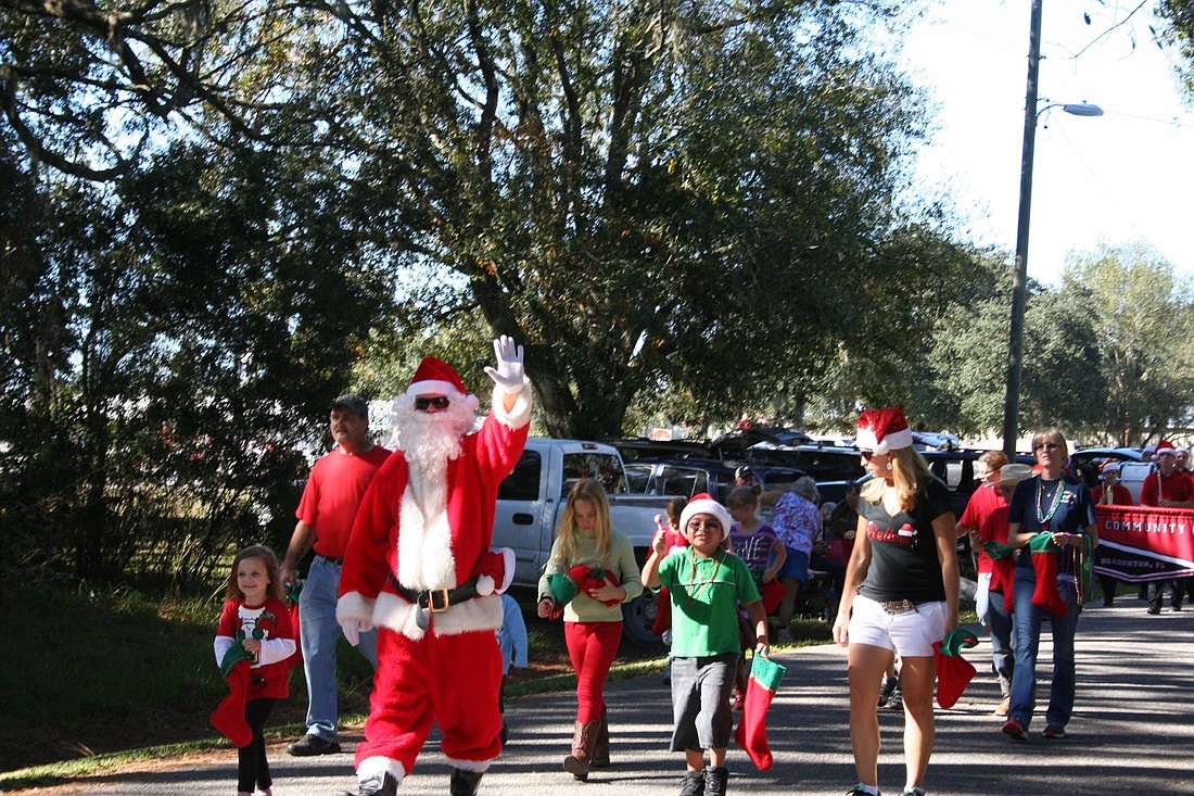 Santa leads a group of children through the Myakka Country Christmas parade. Courtesy photo.