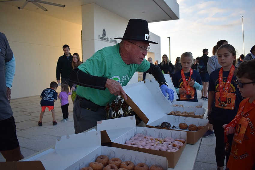 Tara's Lynn Hollabaugh hands out donuts to the children who had finished their race.