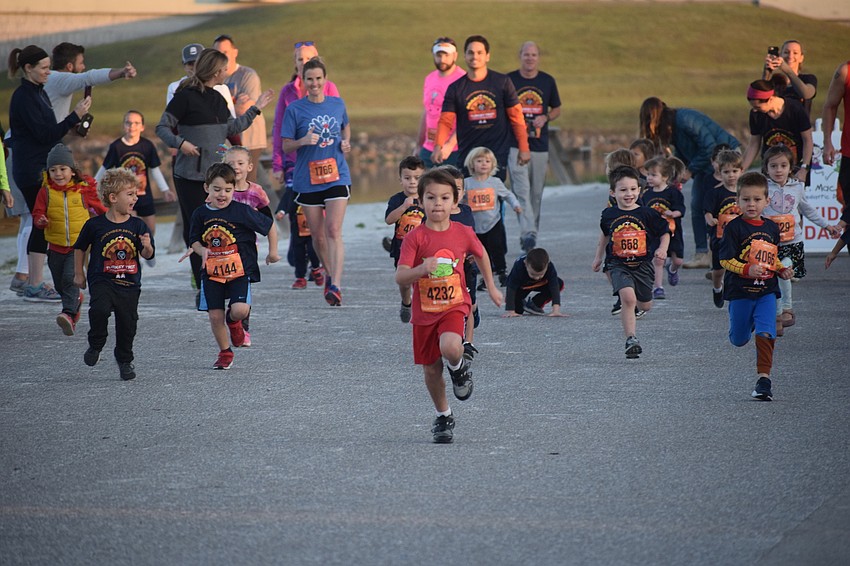 Bradenton's Xavier Fisher, 4, breaks away from the field to win the first kids race of the day.