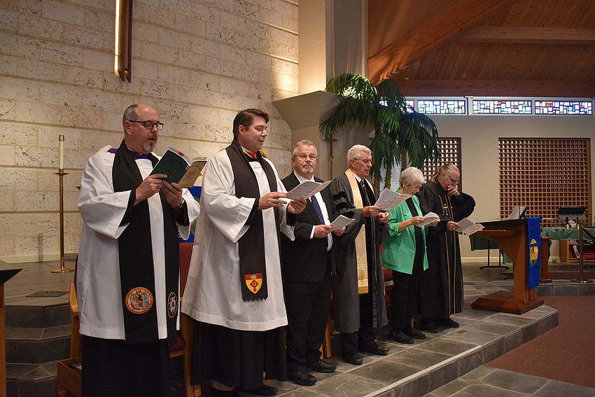 The speakers welcome attendees to the service.