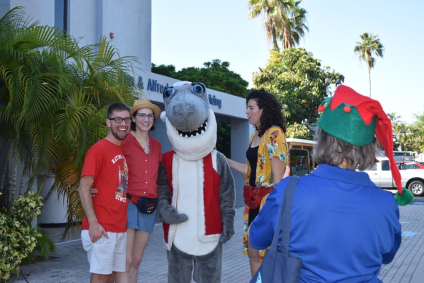 Sharon Dickman gets ready to snap a photo of Josh and Catherine Hayes and Greer Babbe with Santa Jaws.