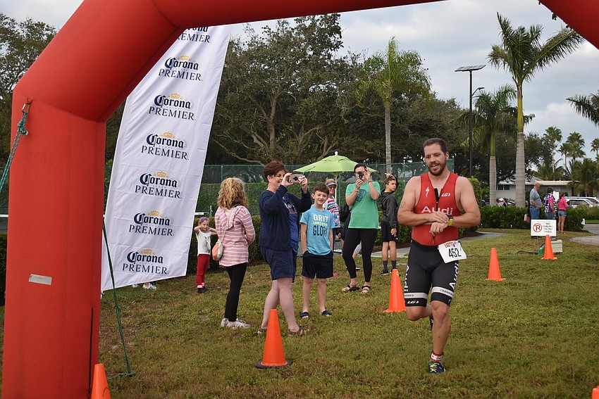 Elliot Sweat stops his watch at the end of the sprint triathlon.
