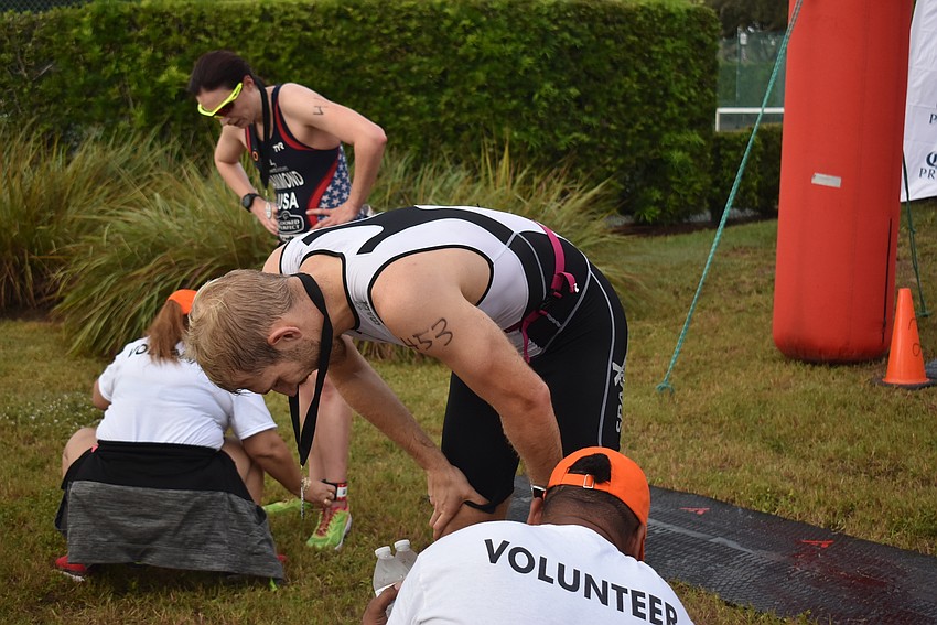 Bego Lopez and Elliot Sweat have their chip timers taken off by Rafael Jiminez and Solange Perez.
