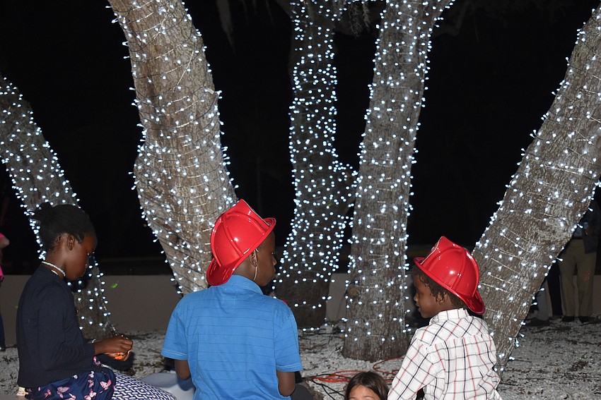 Kids gather beneath the tree.