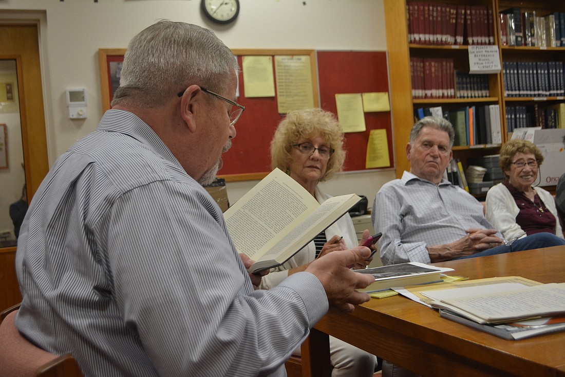 Rabbi Stephen Sniderman (far left) reads from a passage from a history book, while (from middle left to far right) Lois Barson, Mort Tarter and Gloria Sabin listen.